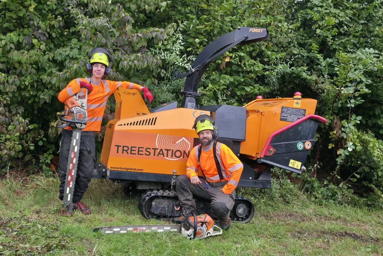 two treestation team members with a stump grinder